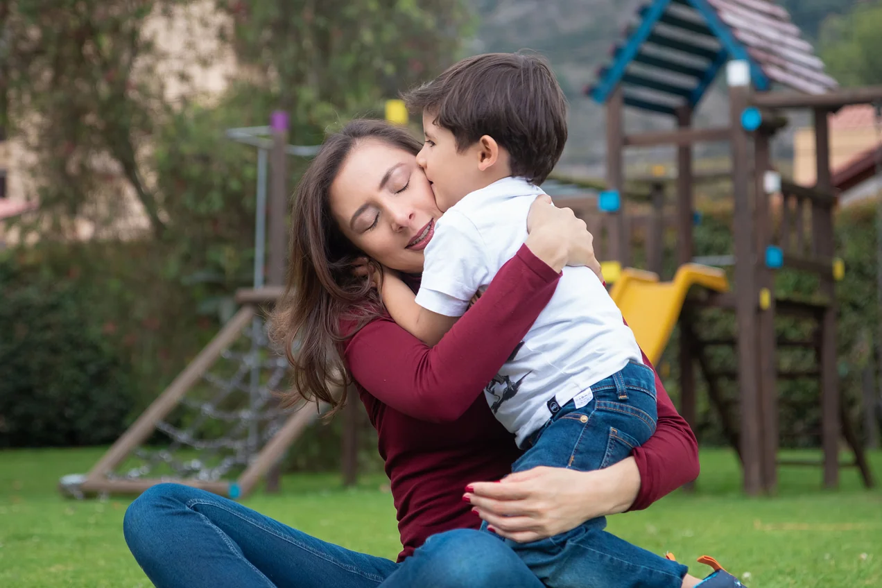 Alexandra Páramo abraza a un niño sentada en el jardín