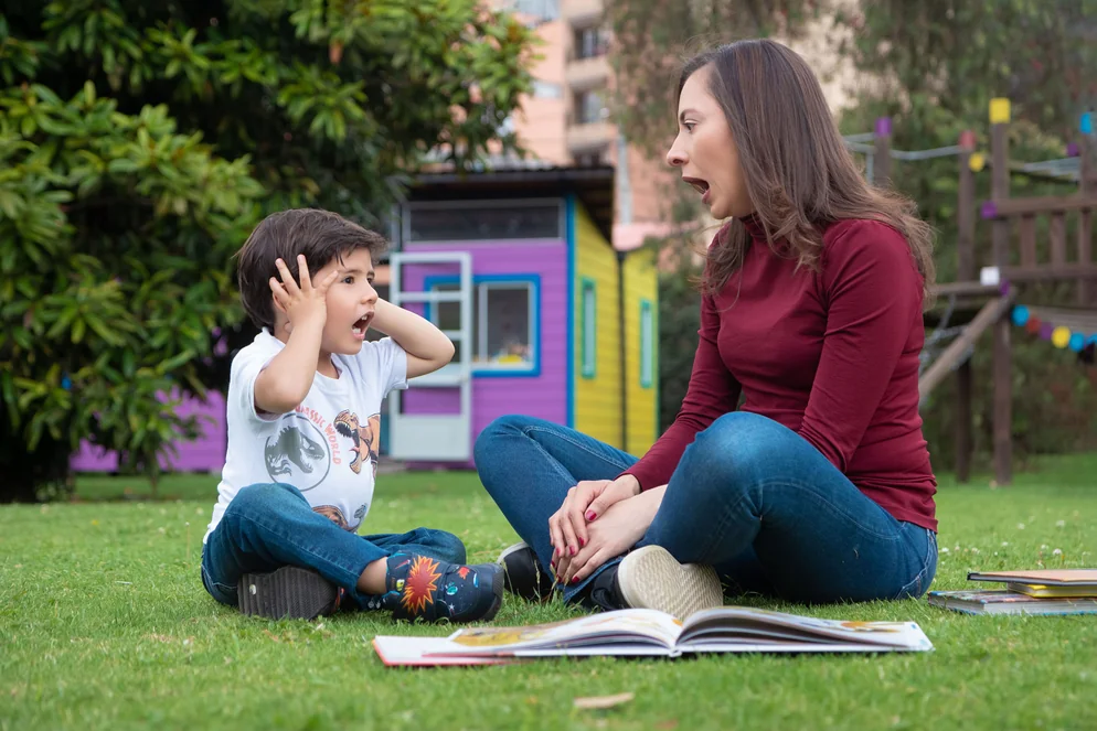 Alexandra Páramo mira a un niño que hace gestos junto a un cuento abierto